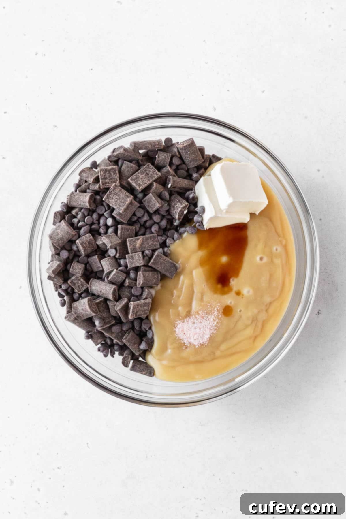 Ingredients for dairy-free fudge added to clear glass bowl.