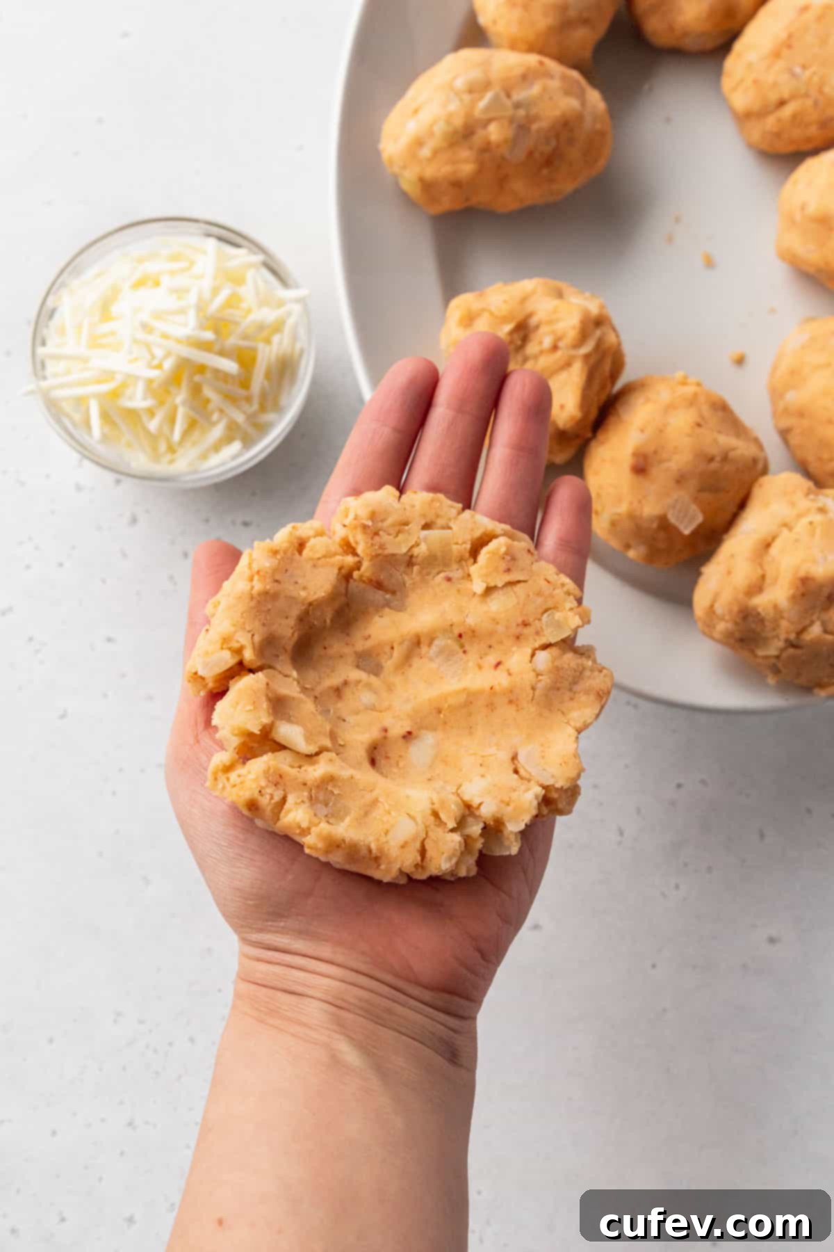 Flattened potato croquette dough is shaped like a burger patty and has thumb indents in the center for stuffing with cheese.