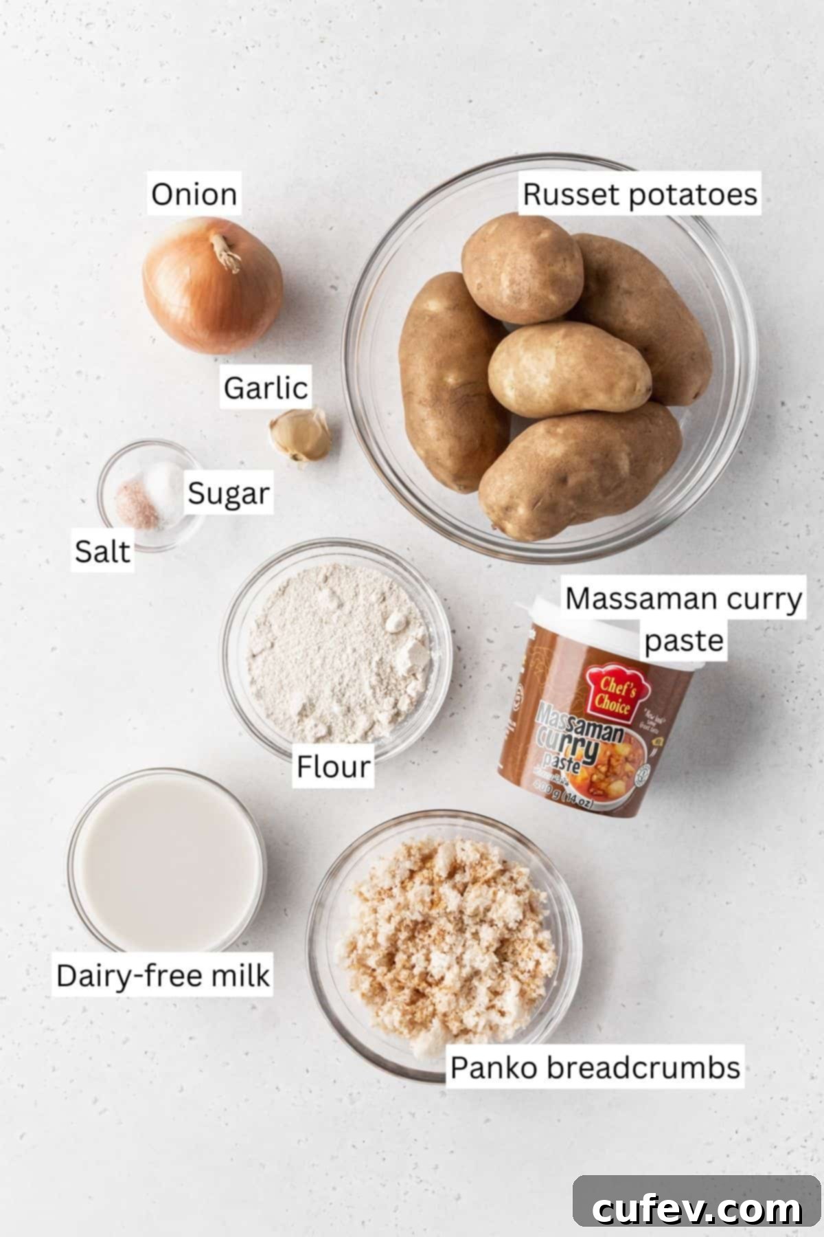 Ingredients for making vegan potato croquettes measured out into bowls on a white surface with text overlay.