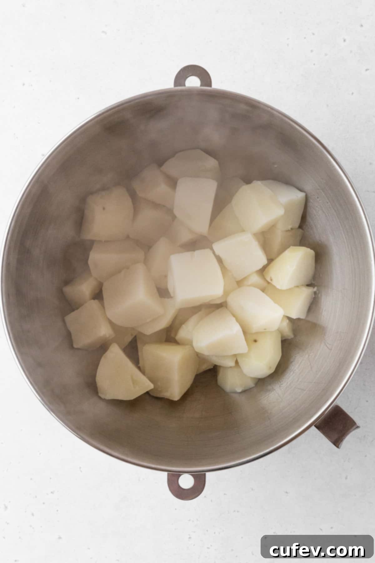Drained potatoes in a mixing bowl.