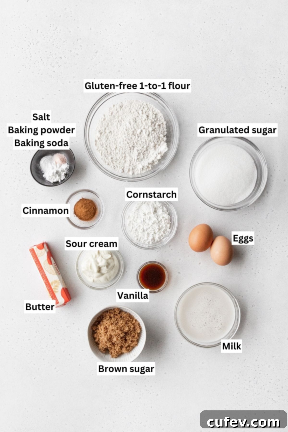 Ingredients for making gluten-free coffee cake with crumb topping measured out into small bowls and laid on a white tabletop, ready for baking.