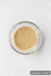 Wet ingredients for making gluten-free coffee cake mixed together in a bowl, a smooth, creamy consistency.