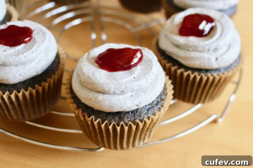 Frosted black sesame cupcakes, each with a dollop of red berry jam (fake blood) in the center.