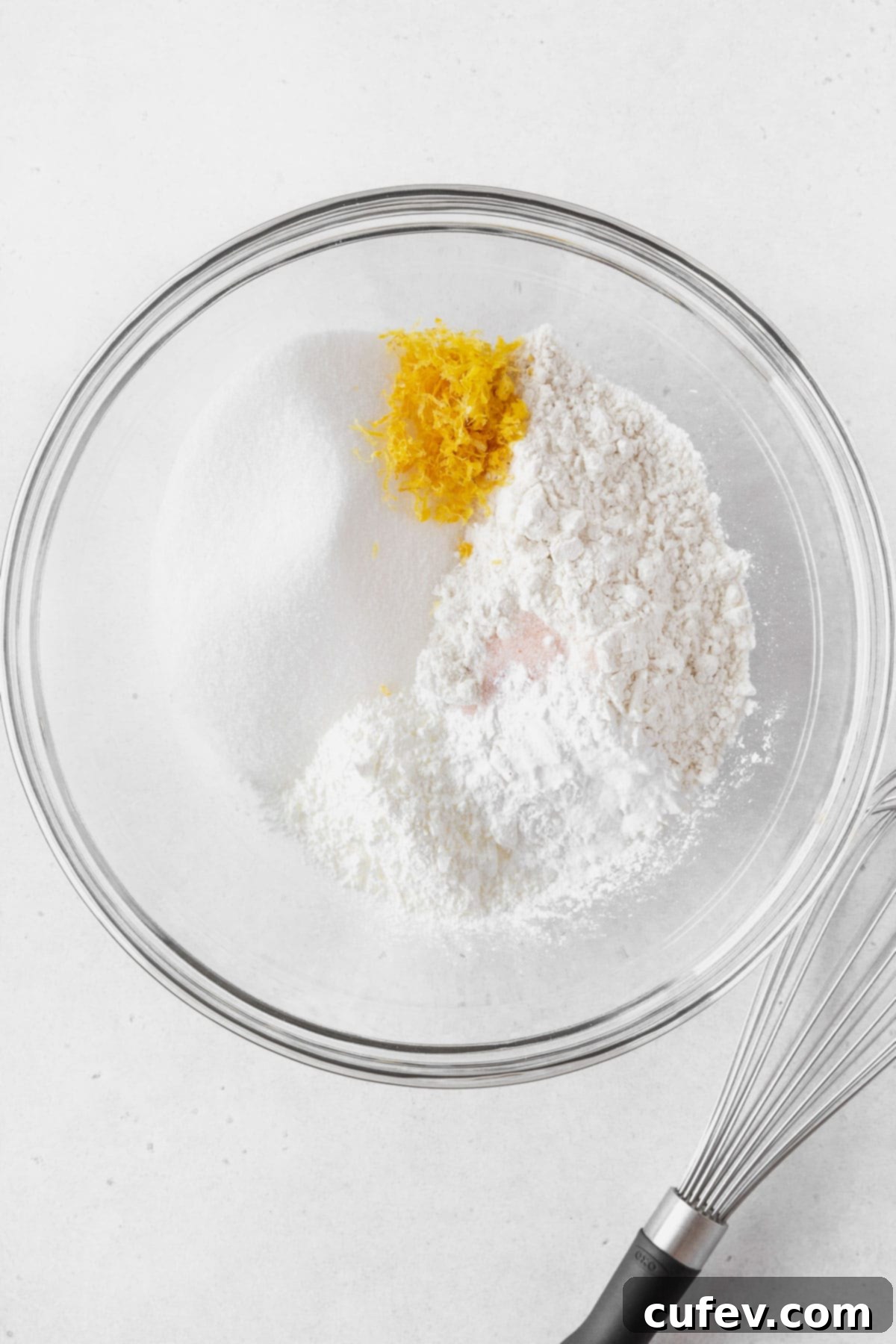 Adding the dry ingredients and lemon zest in a bowl.