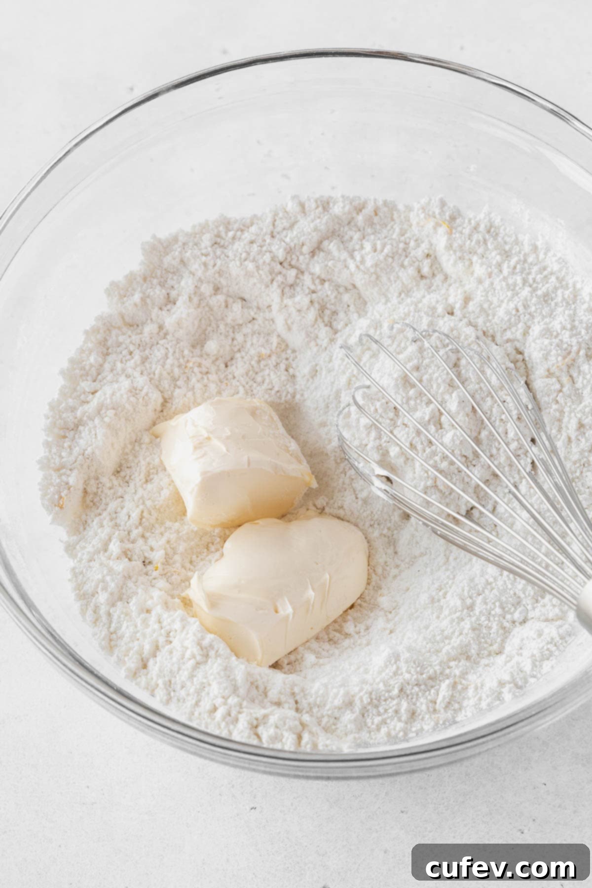 Mixing softened butter into the dry ingredients.