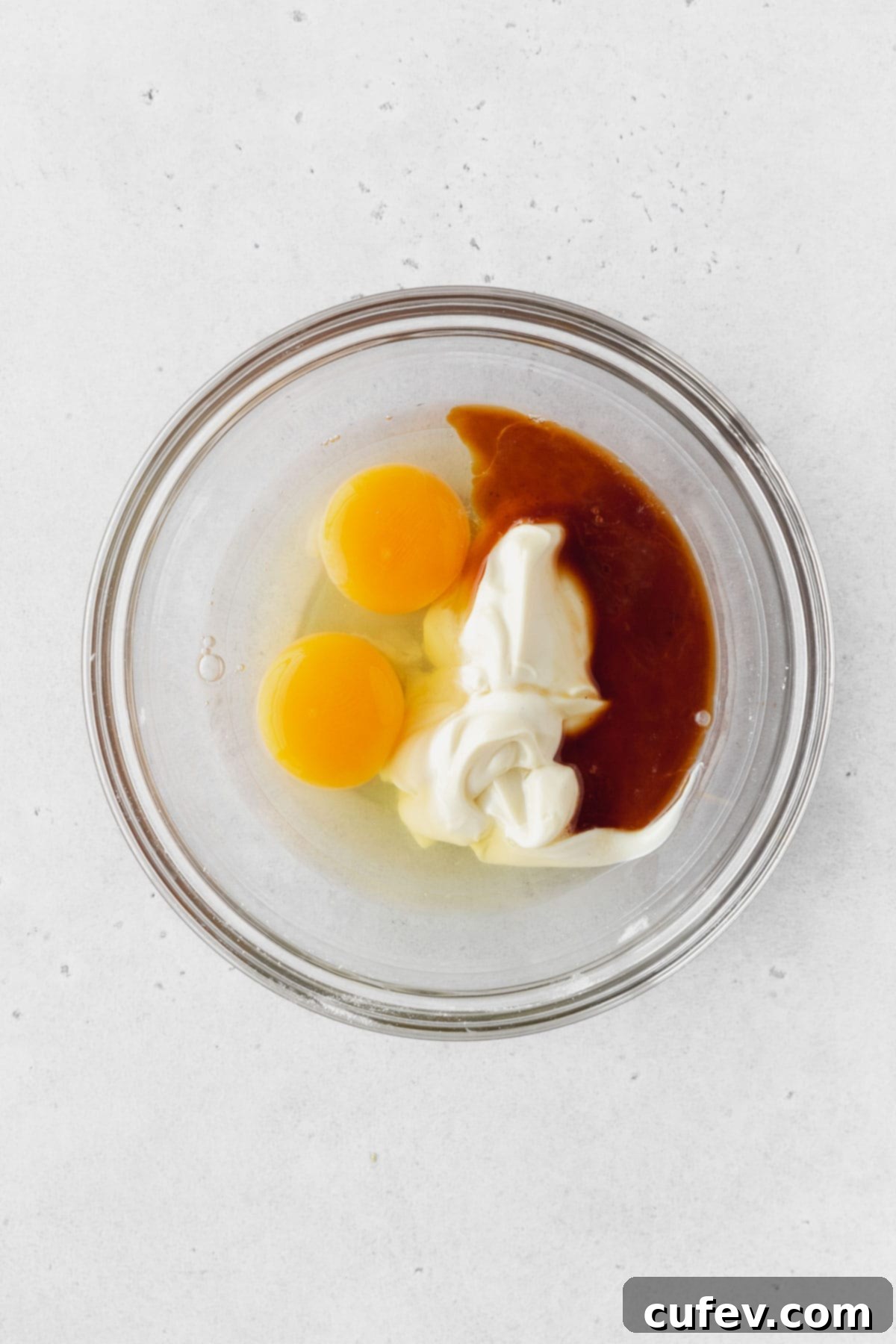 Mayo, eggs, and vanilla in a bowl before whisking.