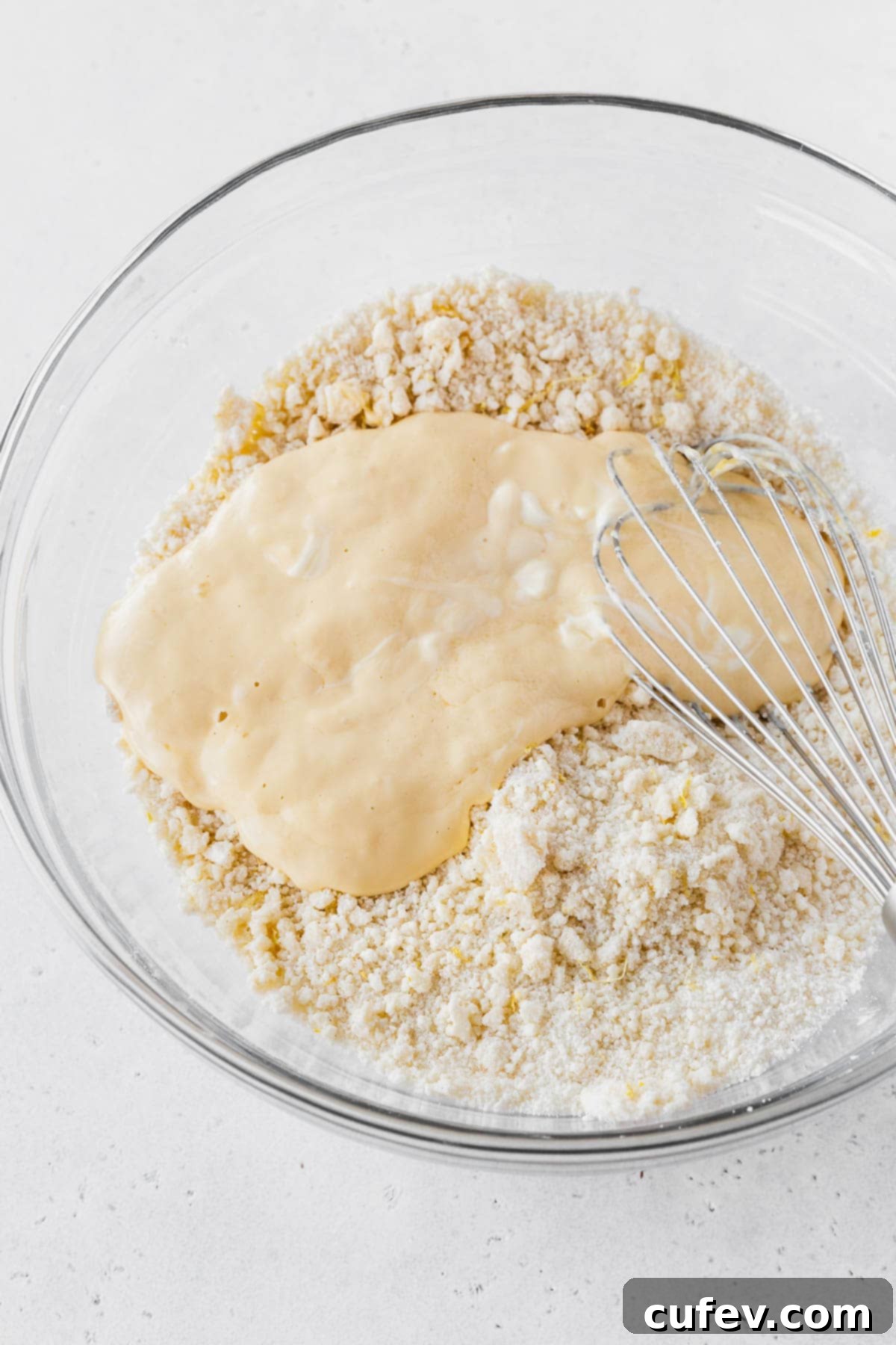 Wet ingredients added to dry ingredients for the lemon layer cake recipe.