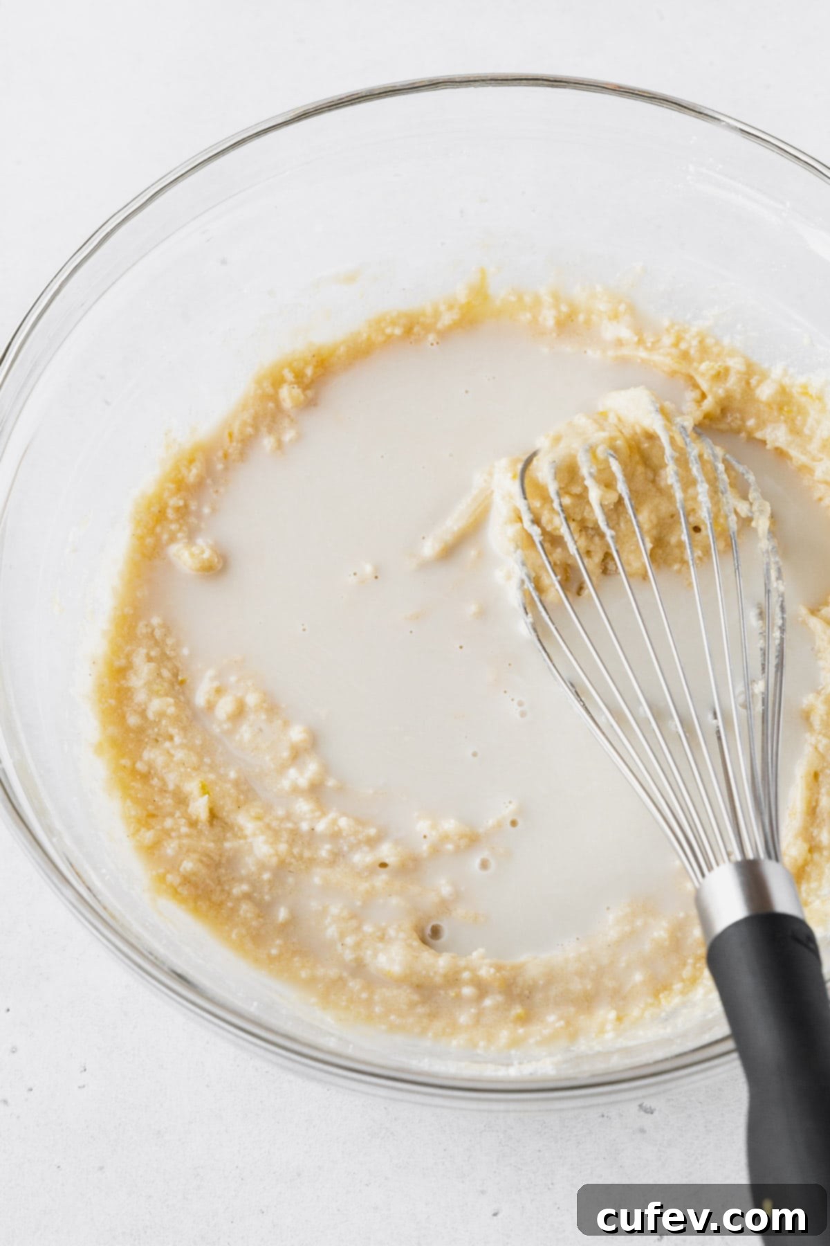 Adding the plant-based milk to the lemon cake batter.