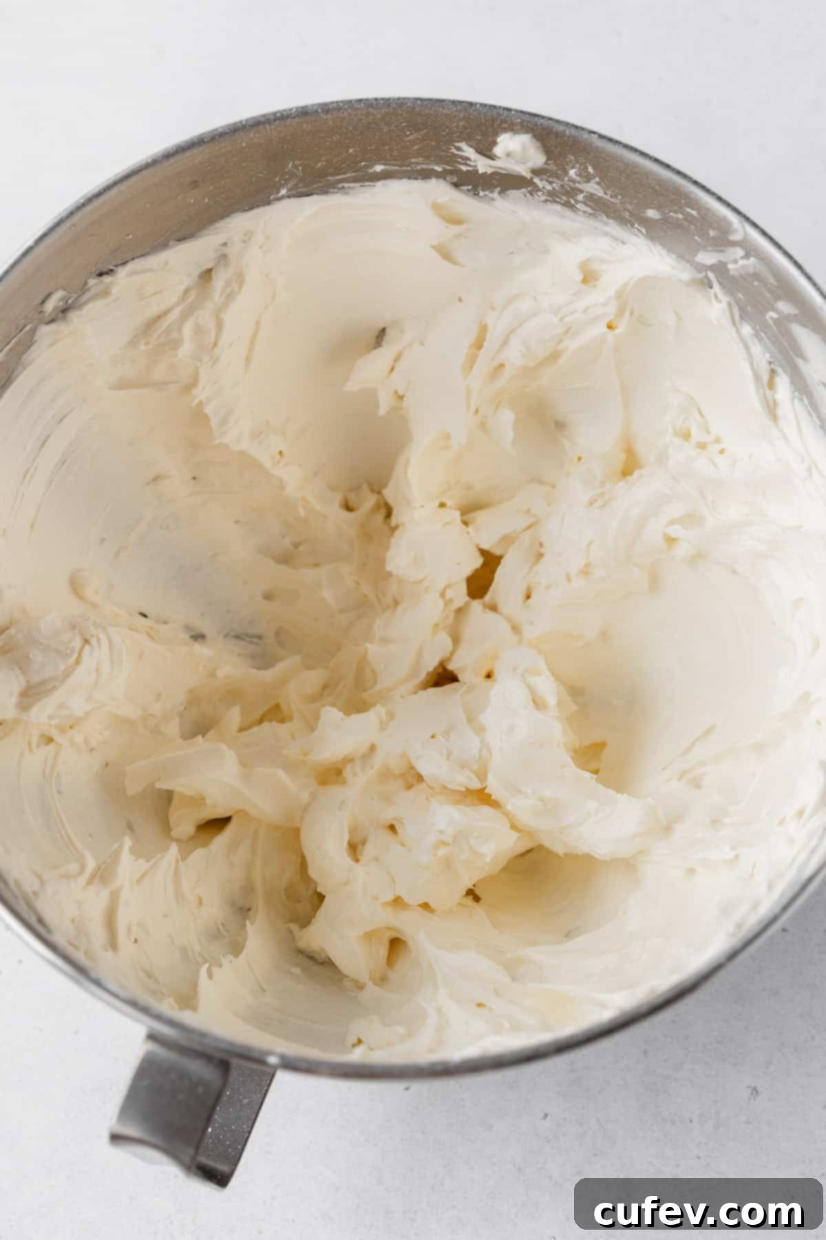 Completed lemon buttercream frosting in the bowl of a stand mixer.