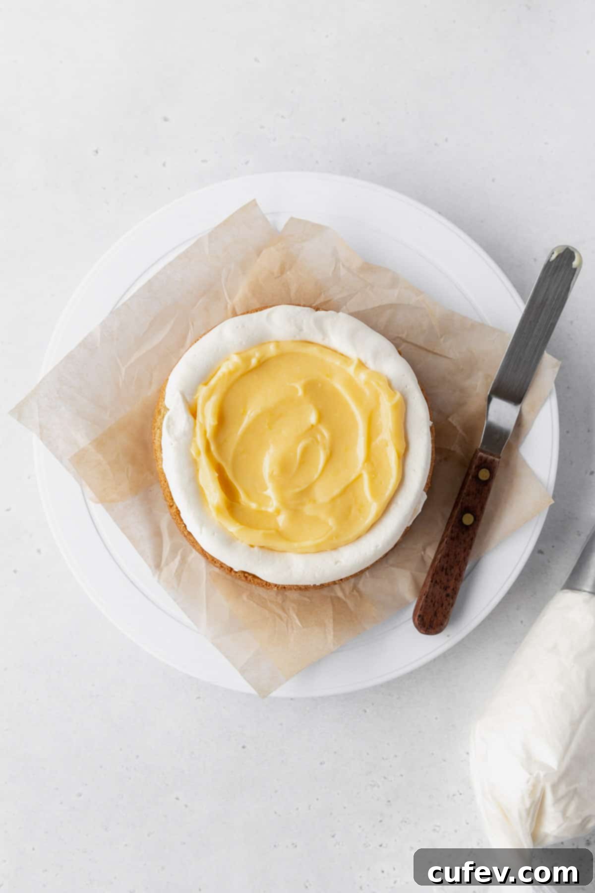 Flooding the center of the cake layer with lemon curd.