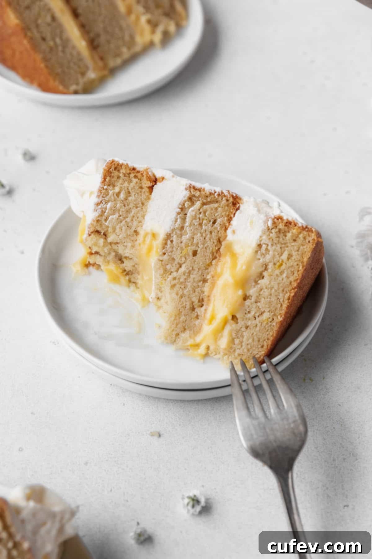 Close-up hero shot of a few bites taken out of the lemon curd cake.