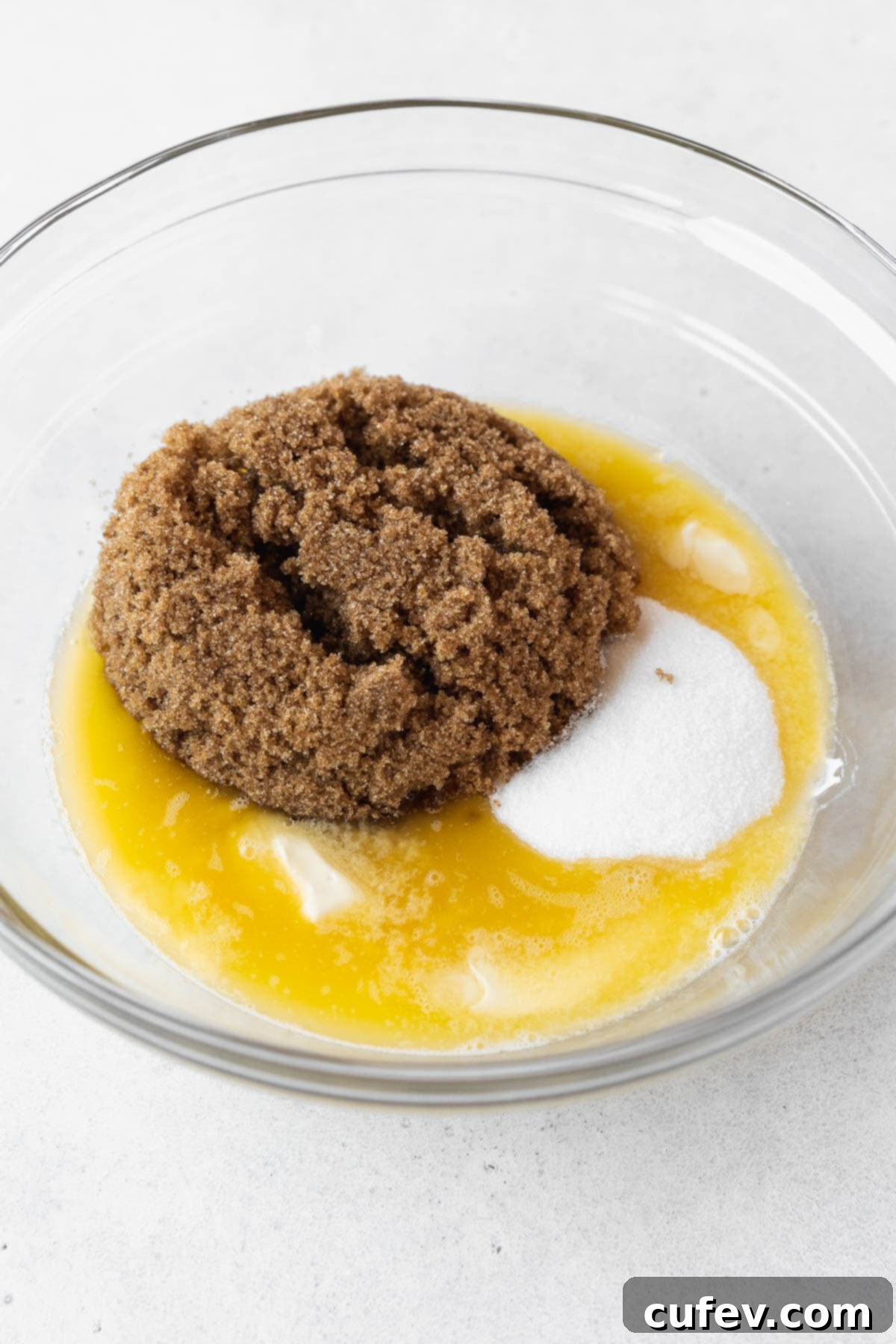 Adding sugars to the melted butter in a bowl.