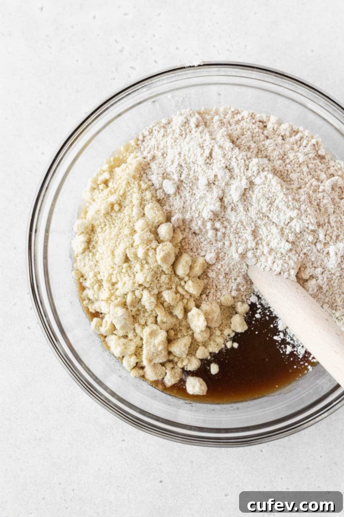 Step 2 for making vegan edible cookie dough -- almond and oat flours added to sugar-butter mixture in a bowl.