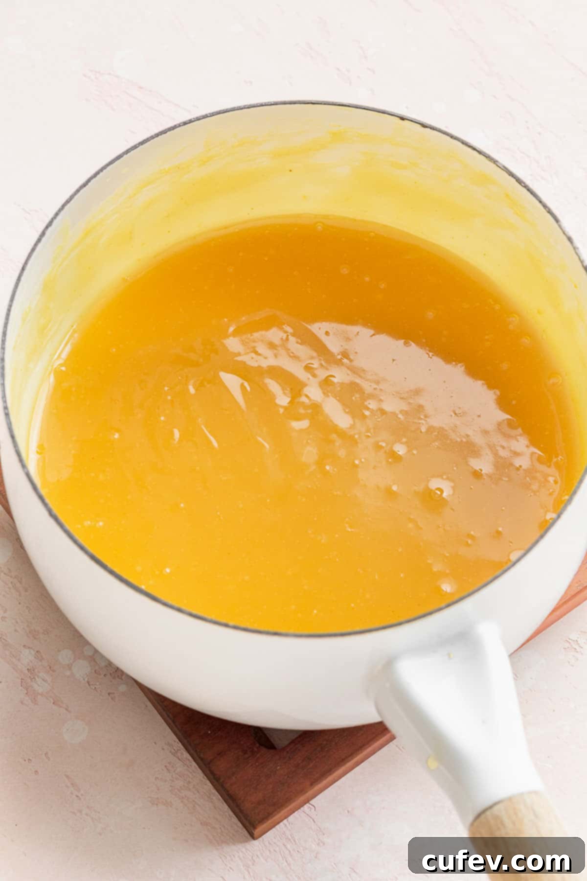 Velvety Vegan Lemon Curd 8 completed lemon curd in a sauce pan. it is bright yellow like the color of an egg yolk, ready to be cooled.