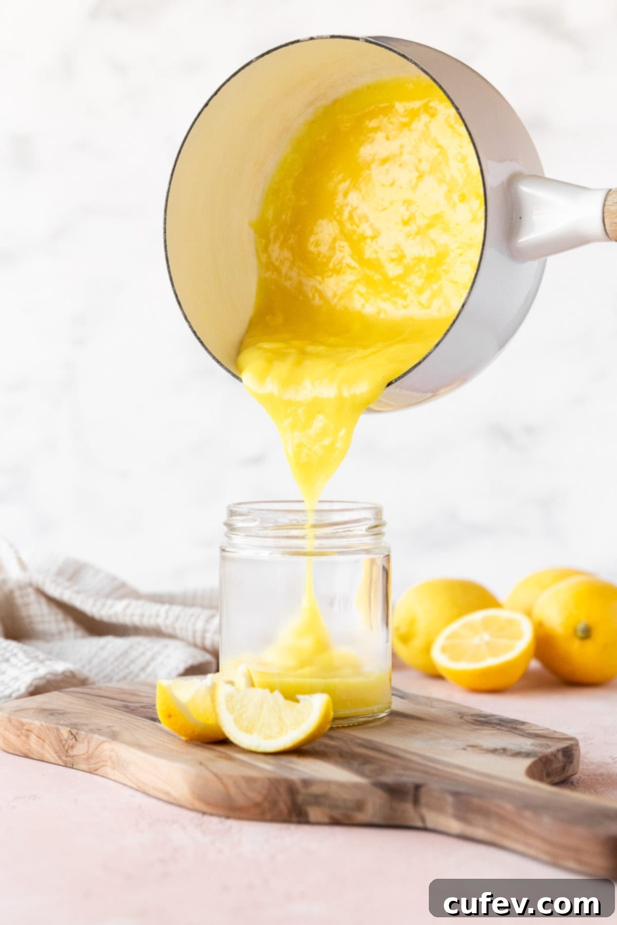 Velvety Vegan Lemon Curd 9 Pouring the vegan lemon curd from a saucepan into a mason jar, capturing the smooth, rich texture as it fills the jar.