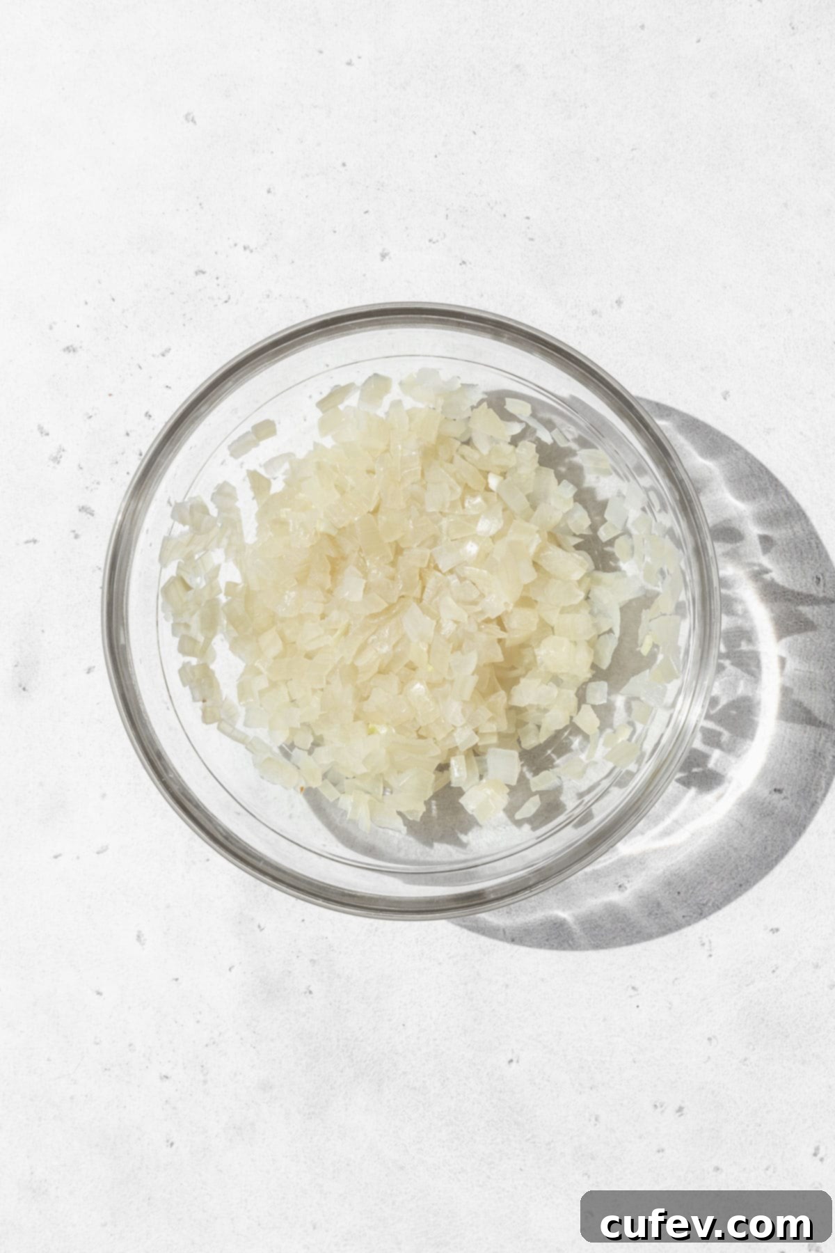 Microwaved minced onion in a glass bowl, ready to be added to the dumpling filling.