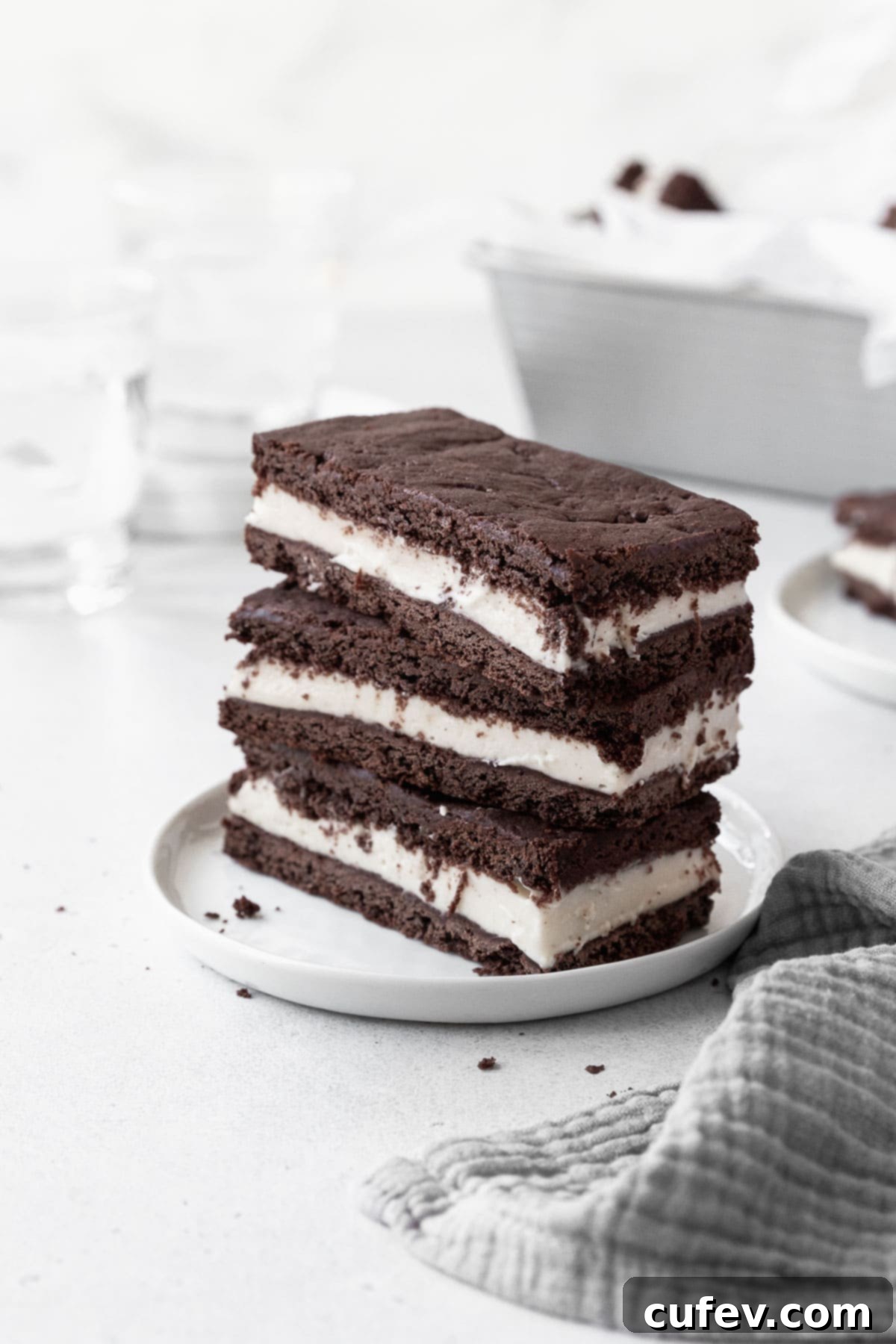 A stack of perfectly crafted gluten-free ice cream sandwich cookies on a pristine white dish, ready to be enjoyed.