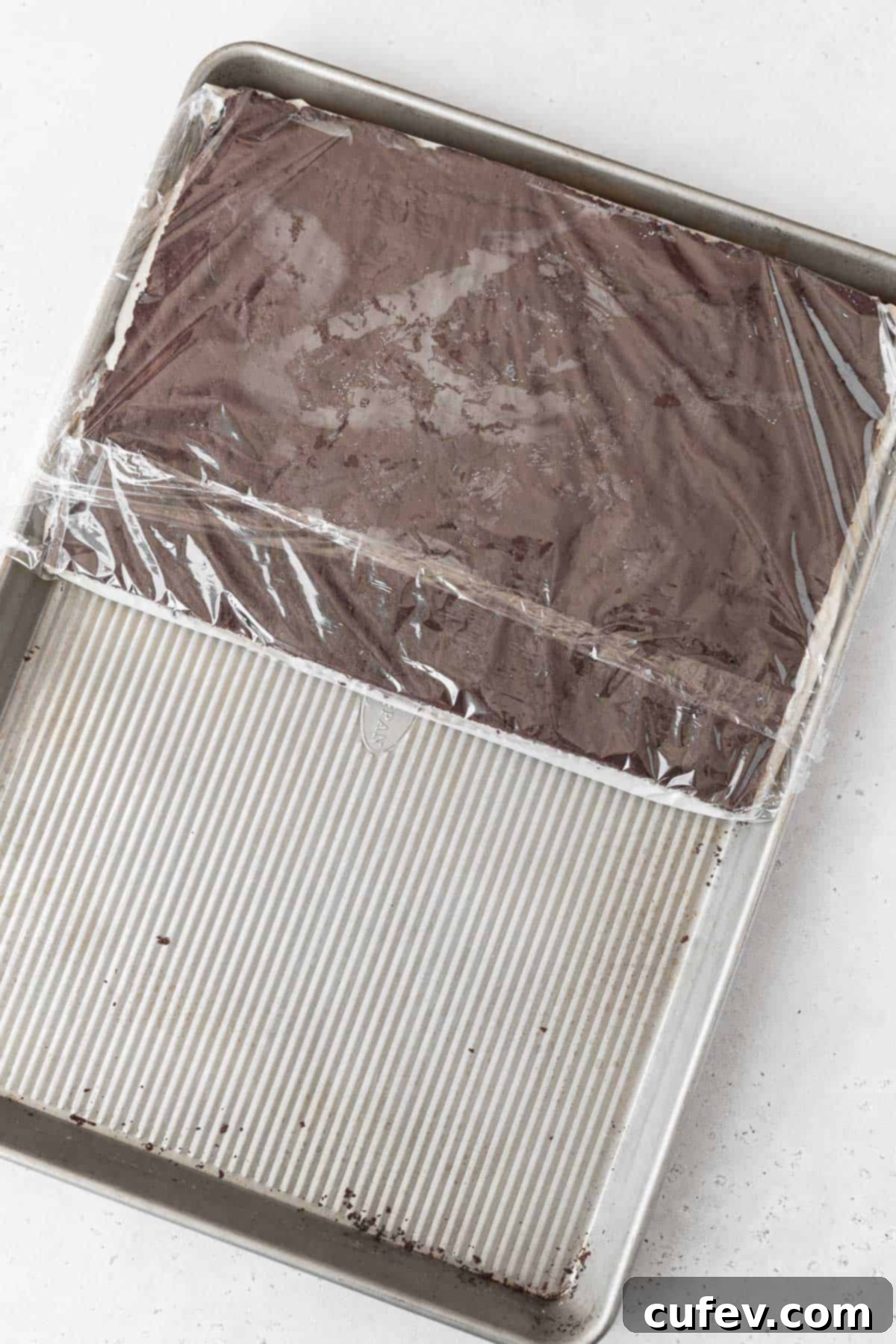 The two layers of gluten-free ice cream sandwich cookies, with the dairy-free ice cream filling, carefully stacked together on a large cookie sheet.