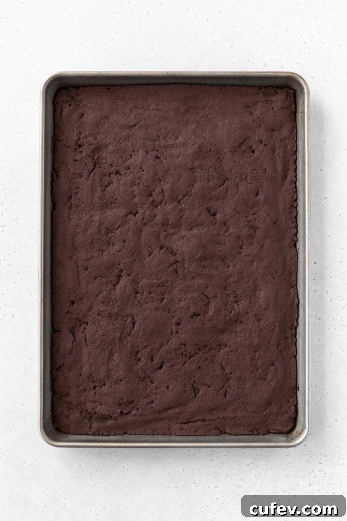 A freshly baked sheet of chocolate ice cream sandwich cookie, perfectly set and cooling on a baking sheet, awaiting the creamy filling.