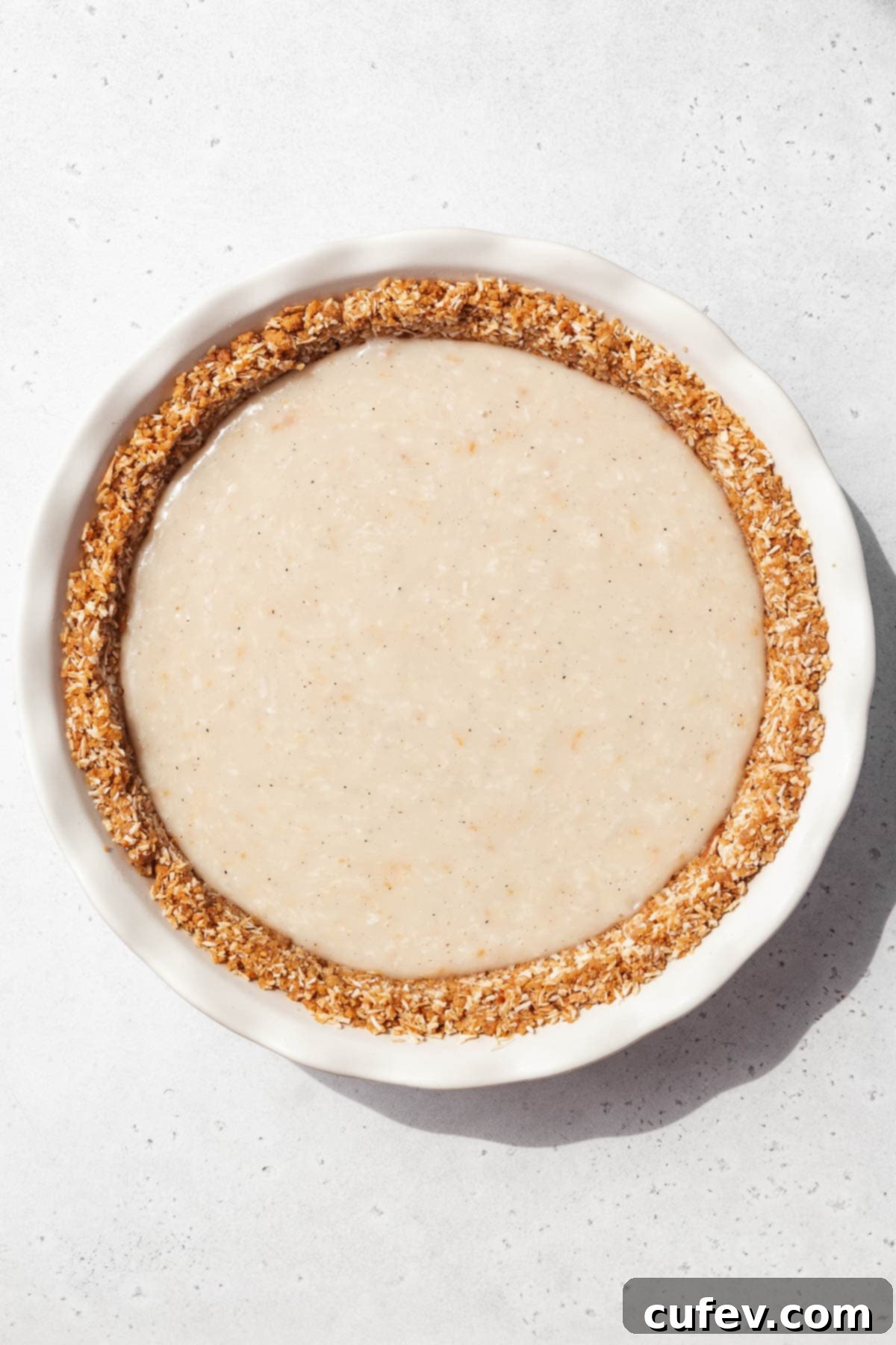 Vegan coconut custard poured into the chilled gluten-free pie crust.