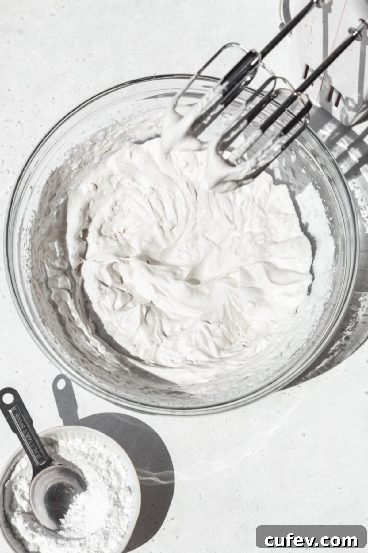 Vegan whipped cream in a mixing bowl after beating to stiff peaks.