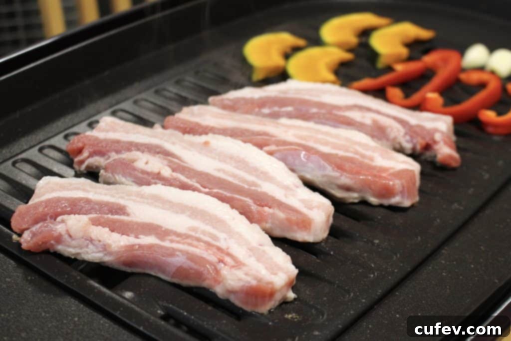 Variety of colorful vegetables including kabocha squash, red bell peppers, garlic, and broccoli sprouts prepared for grilling