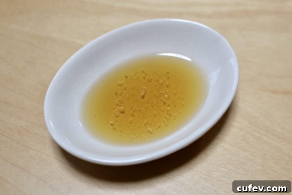 Cooked pork belly being expertly cut into bite-sized pieces with kitchen shears on the grill