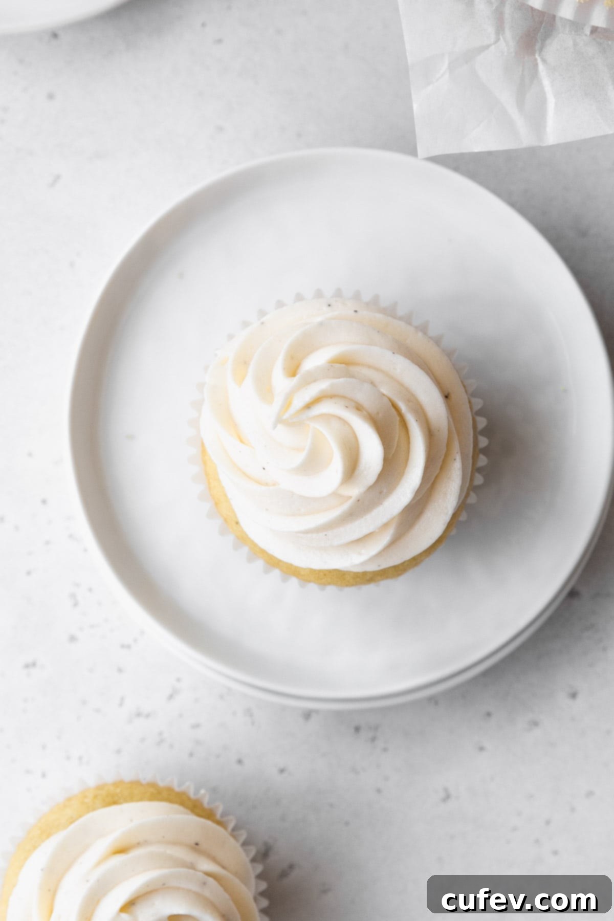 Overhead shot of a vanilla cupcake topped with vegan vanilla buttercream frosting.