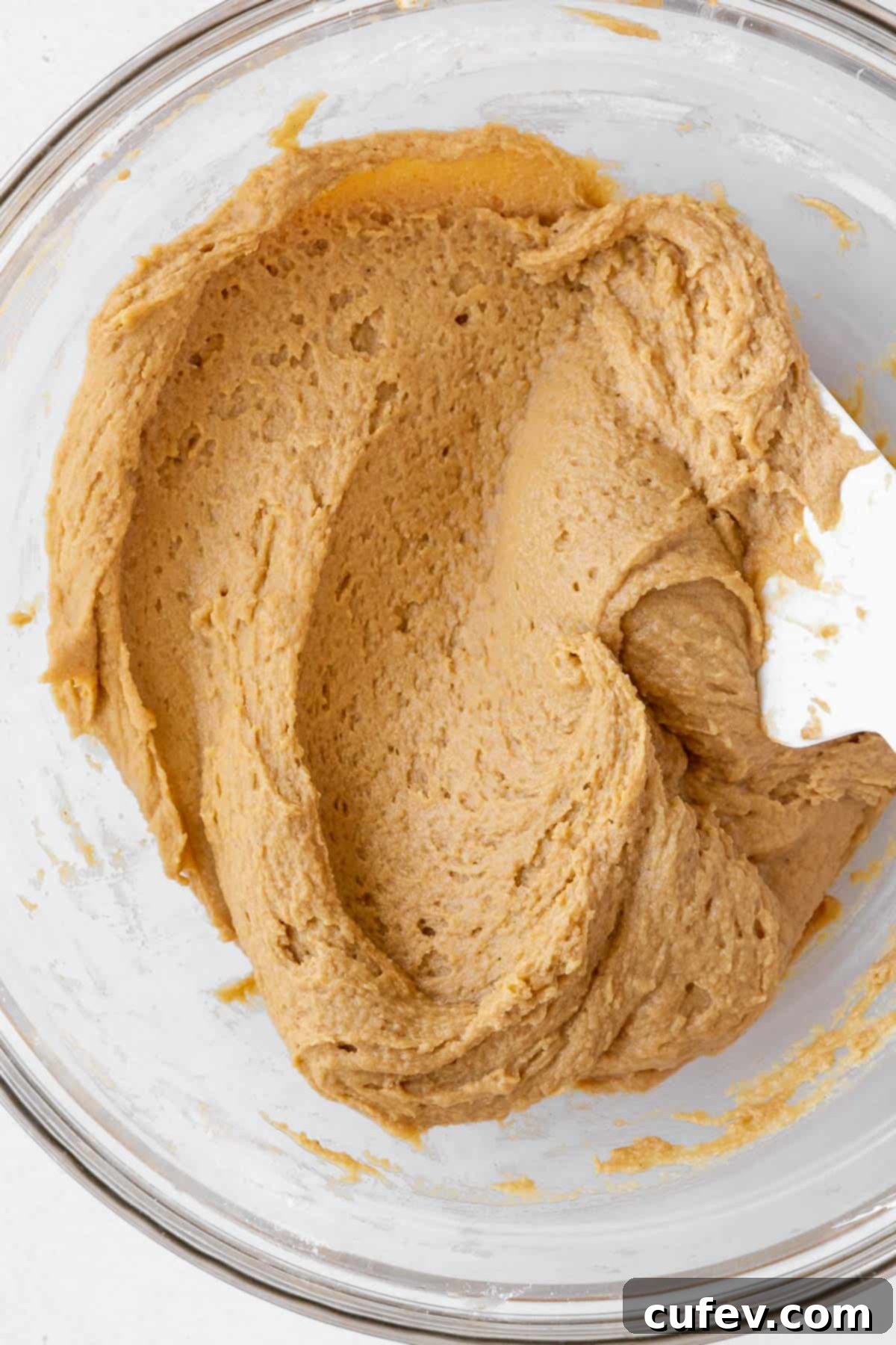 A closeup of the perfectly mixed dairy-free peanut butter cookie dough in a mixing bowl, covered and chilling in the refrigerator.