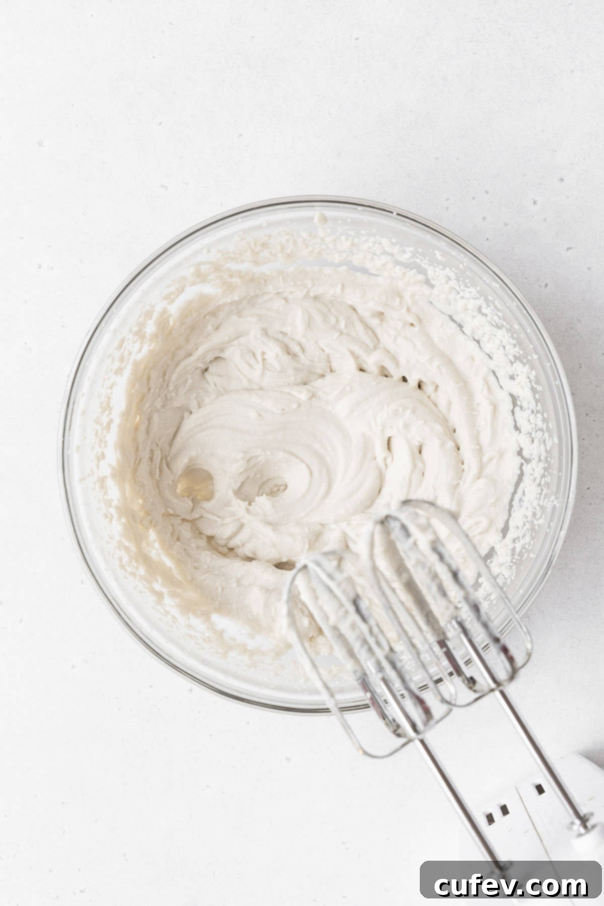 Indulgent Gluten-Free and Dairy-Free Tres Leches Cake 13 Whipping the non-dairy whipped cream in a glass mixing bowl.