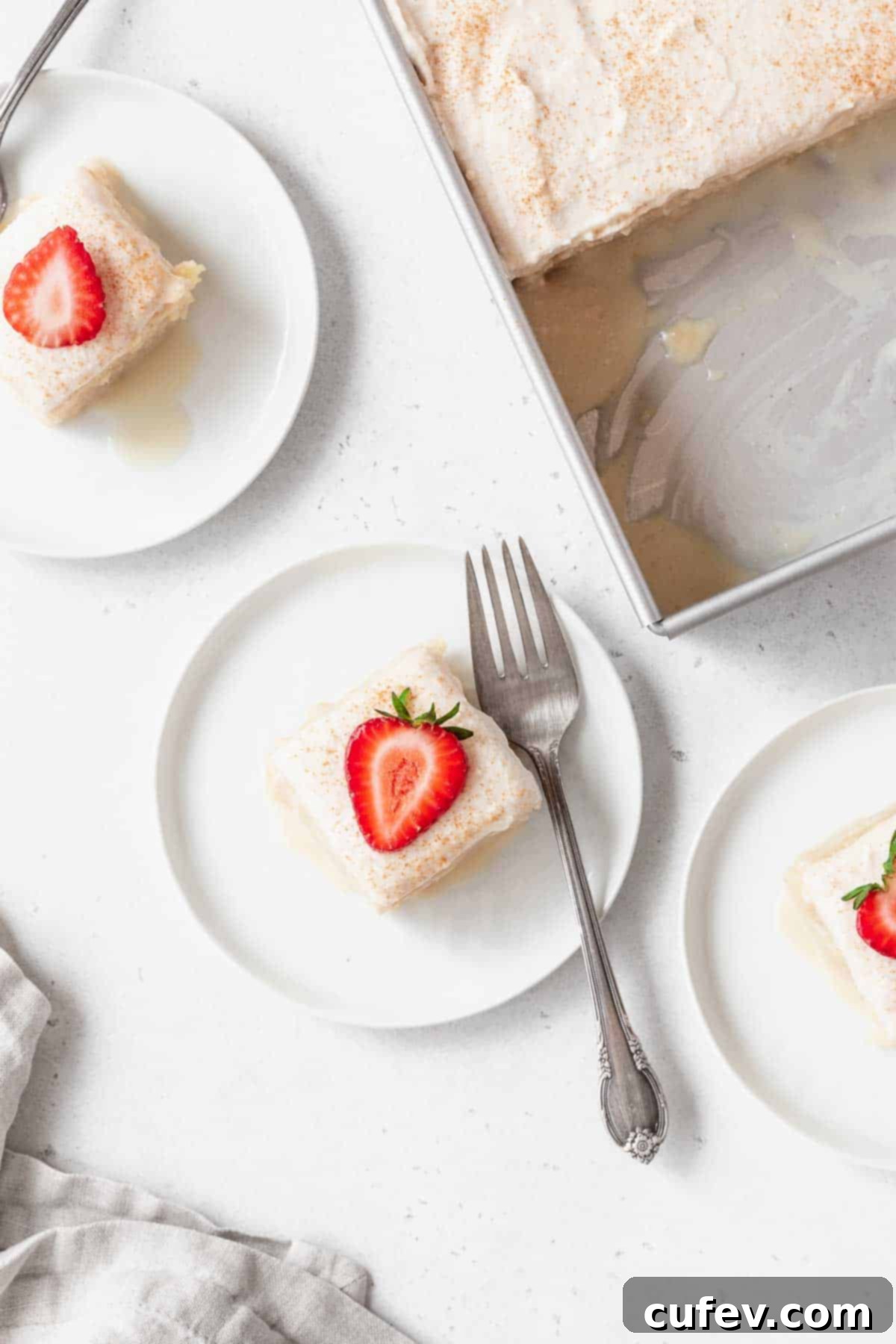 Indulgent Gluten-Free and Dairy-Free Tres Leches Cake 4 An overhead shot of a few small dessert plates of gluten-free tres leches cake next to a pan of the cake.