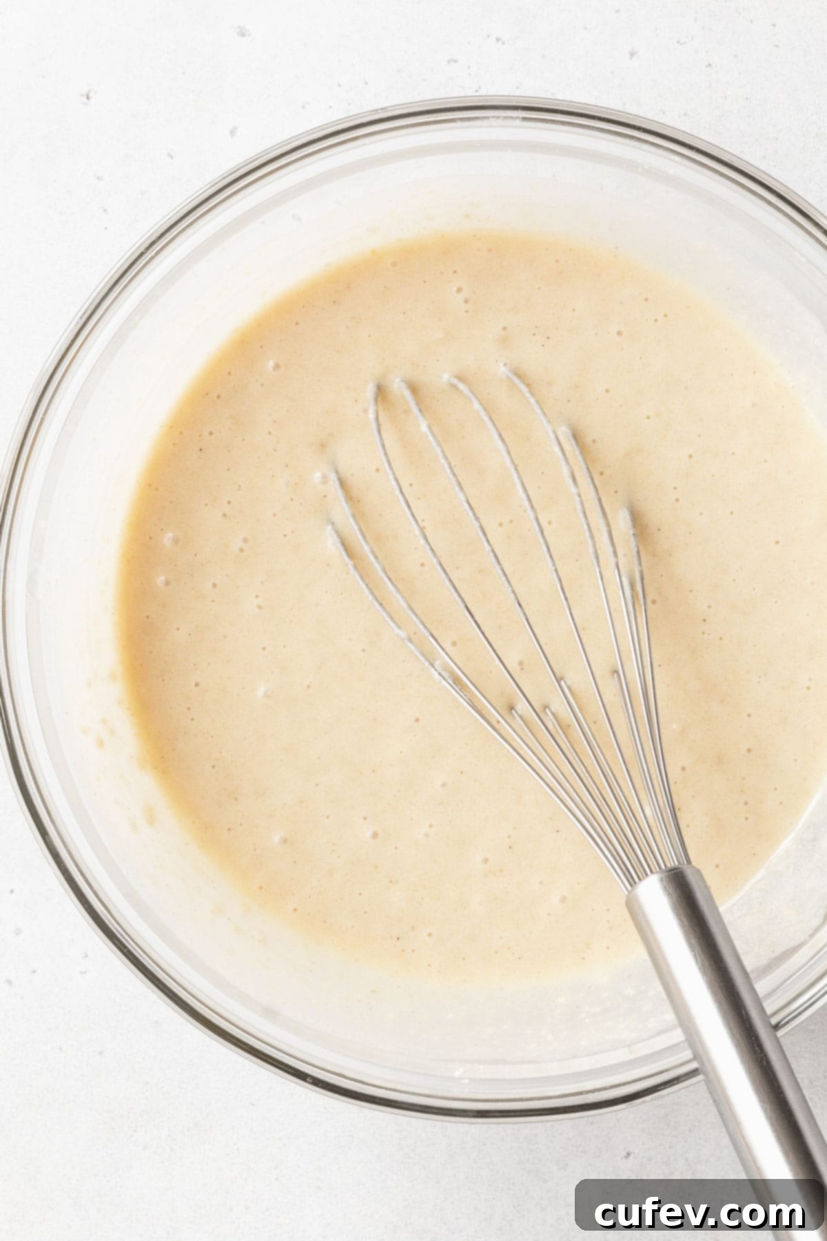 Indulgent Gluten-Free and Dairy-Free Tres Leches Cake 8 The wet ingredients whisked together in a glass mixing bowl.