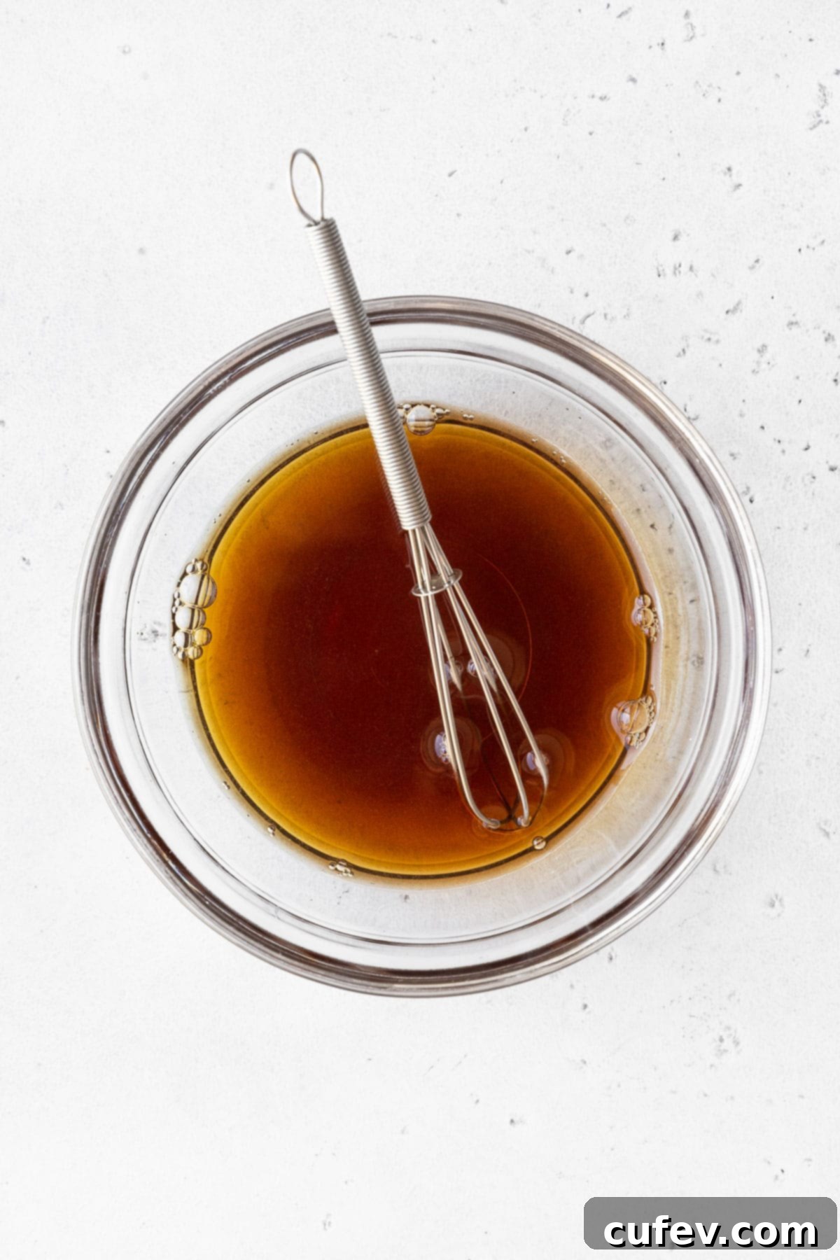 Tropical Mango Bubble Tea 6 Mixing brown sugar and hot water in a small glass bowl to create simple syrup.