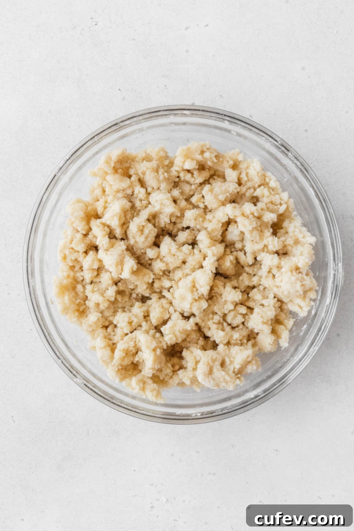 The crumbly dairy-free shortbread crust mixture in a mixing bowl, perfectly textured before being pressed into the baking pan.