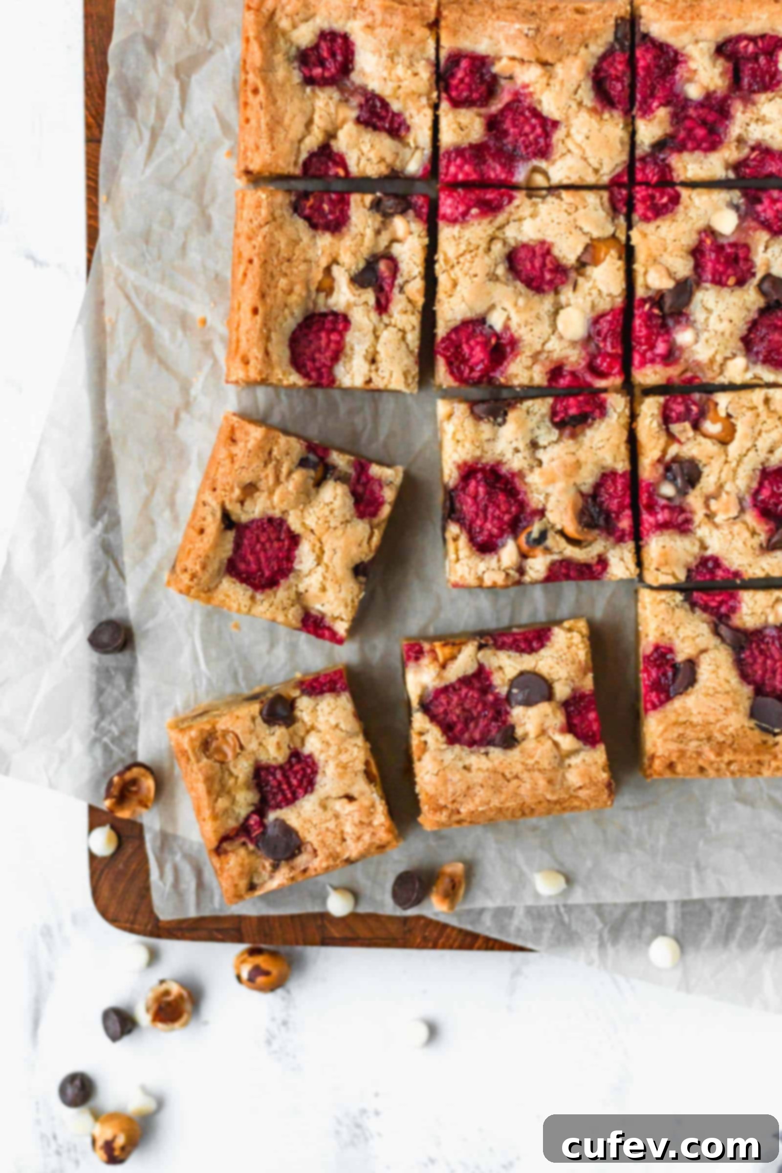 Up close shot of raspberry hazelnut chocolate chip blondies on a serving plate