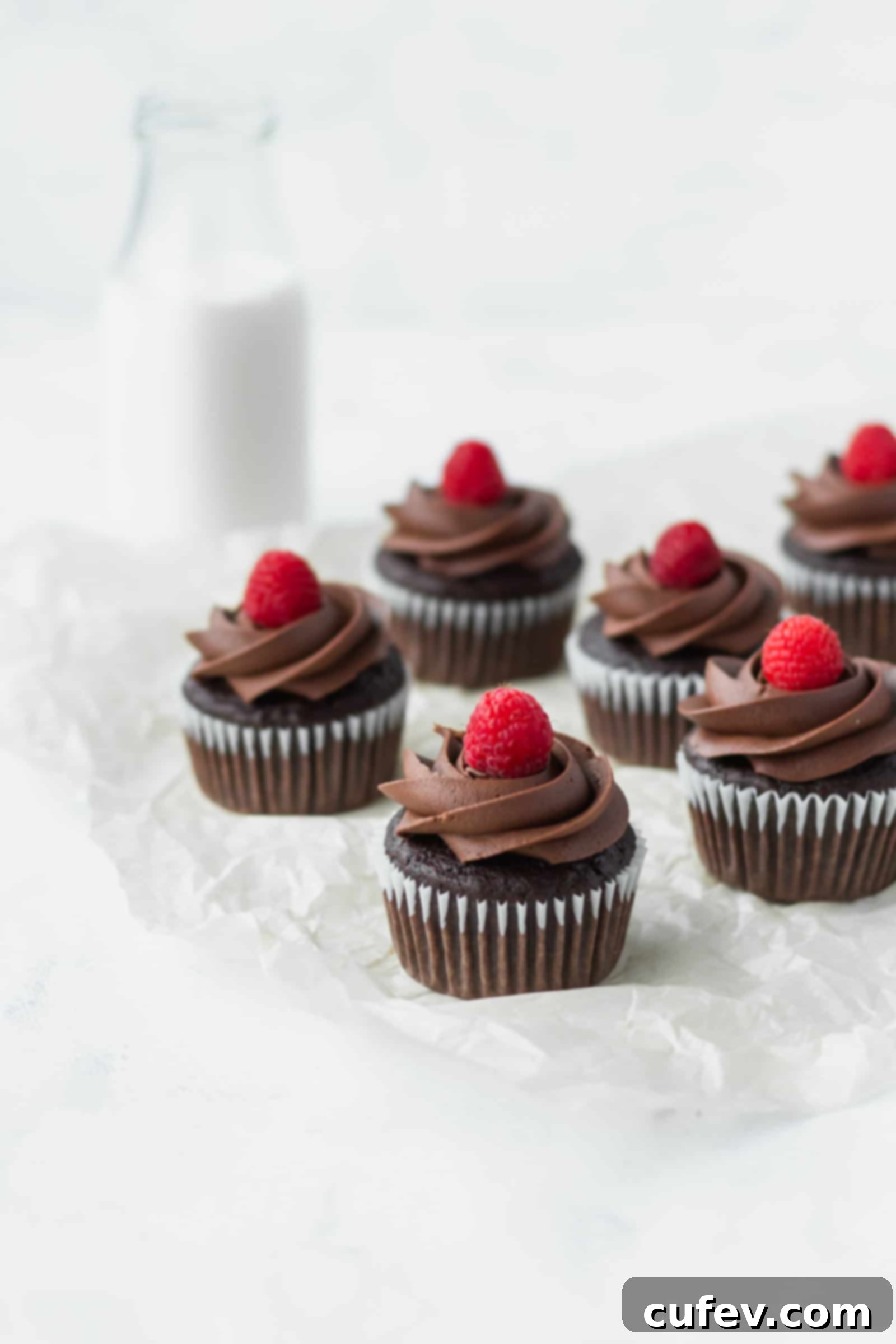 These vegan chocolate banana cupcakes are delicious and moist! Topped with creamy vegan chocolate buttercream and fresh raspberries! #chocolatecupcakes #bananacupcakes #valentinesdaydessert #veganvalentinesday #vegancupcakes