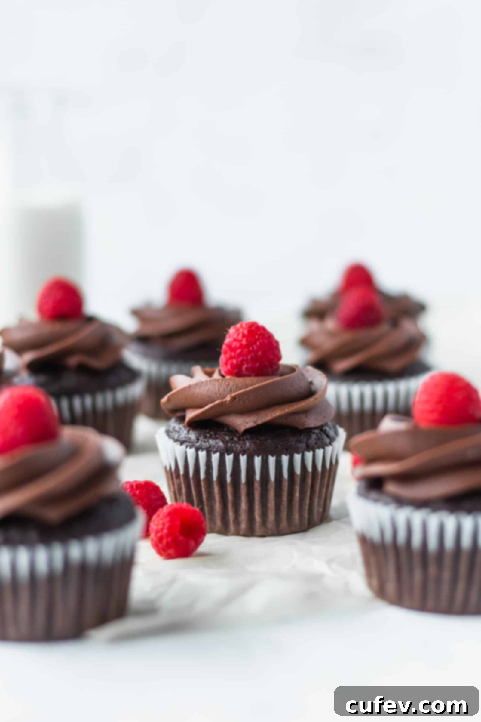 These vegan chocolate banana cupcakes are delicious and moist! Topped with creamy vegan chocolate buttercream and fresh raspberries! #chocolatecupcakes #bananacupcakes #valentinesdaydessert #veganvalentinesday #vegancupcakes