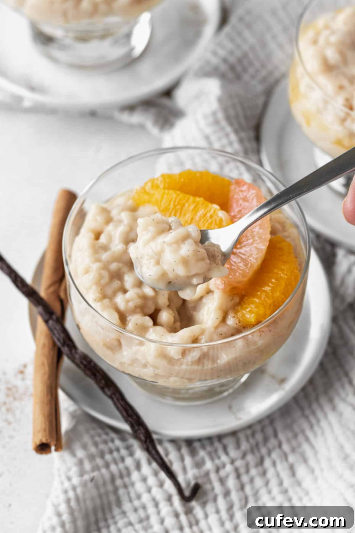 A spoonful of vegan rice pudding over a cup of the pudding.
