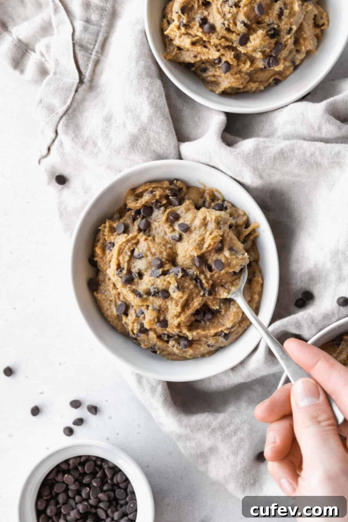 Hand taking a spoonful of dairy-free edible cookie dough from the bowl.