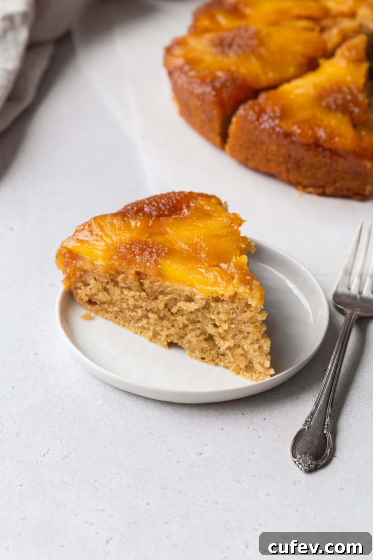 Tropical Gluten-Free Pineapple Upside Down Dream 4 An up-close shot of a slice of gluten-free upside down pineapple cake on a dessert plate.