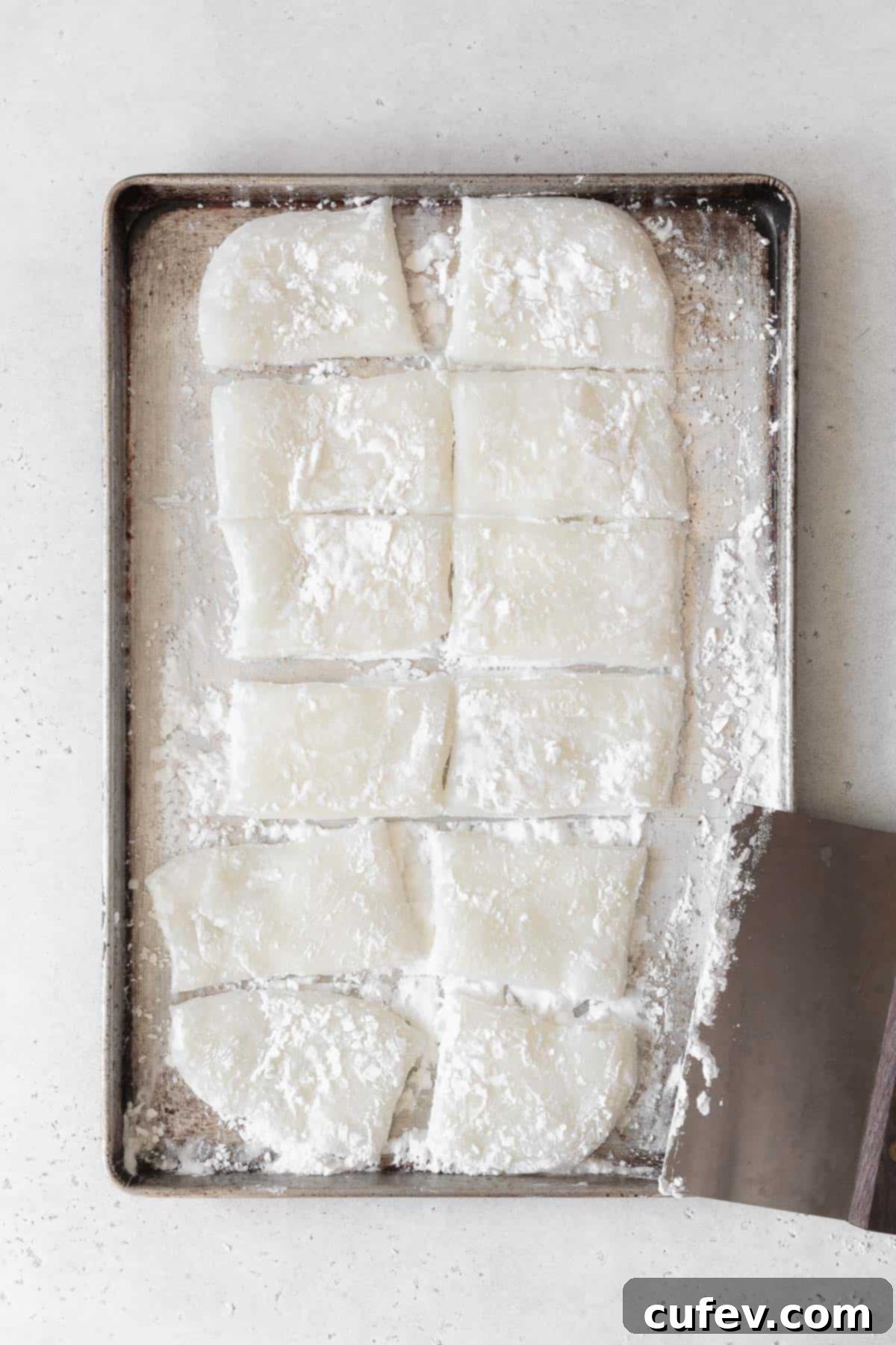Fresh Japanese Strawberry Mochi 13 Mochi cut into 12 pieces using a bench scraper.