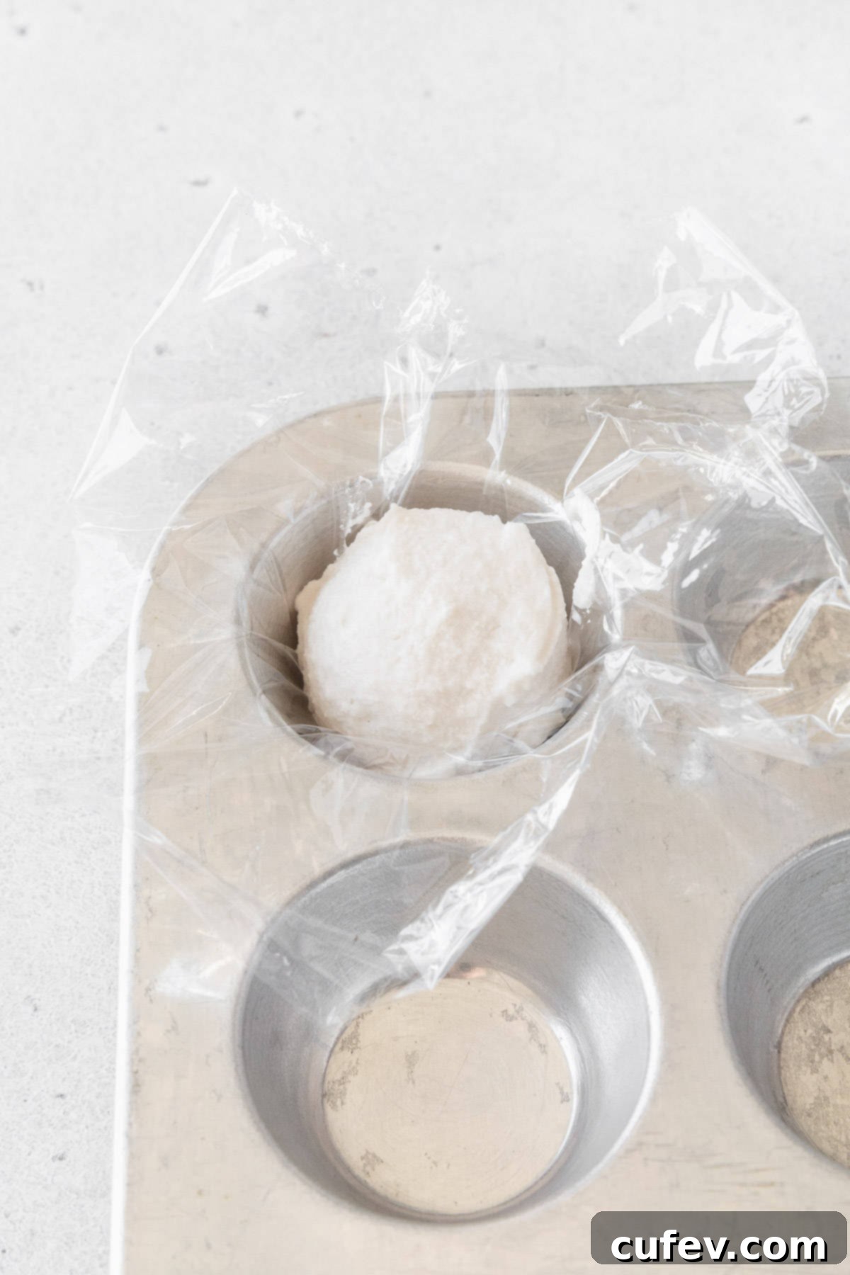 Fresh Japanese Strawberry Mochi 16 A portion of oat whipping cream in a mini muffin tin lined with plastic wrap.