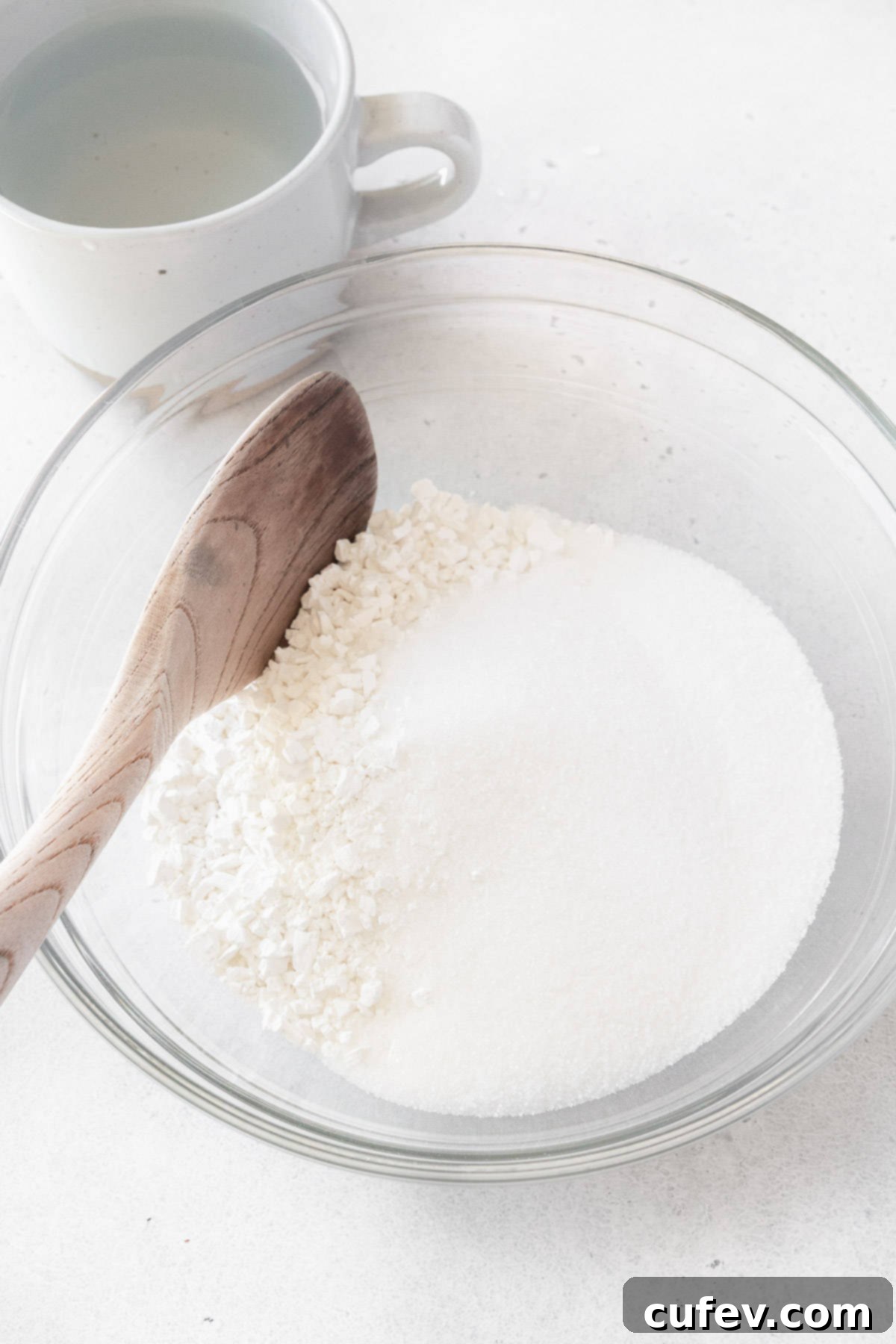 Fresh Japanese Strawberry Mochi 8 Shiratamako and sugar in a glass bowl with a mug of water next to it.