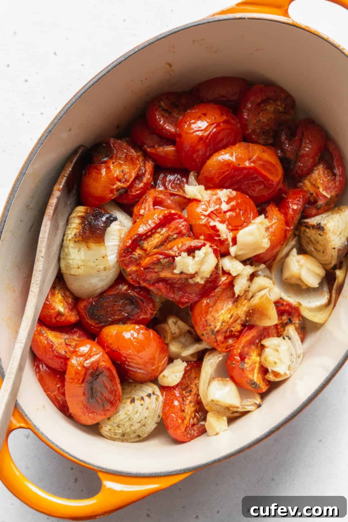 A large pot full of roasted tomatoes, onions, and garlic.