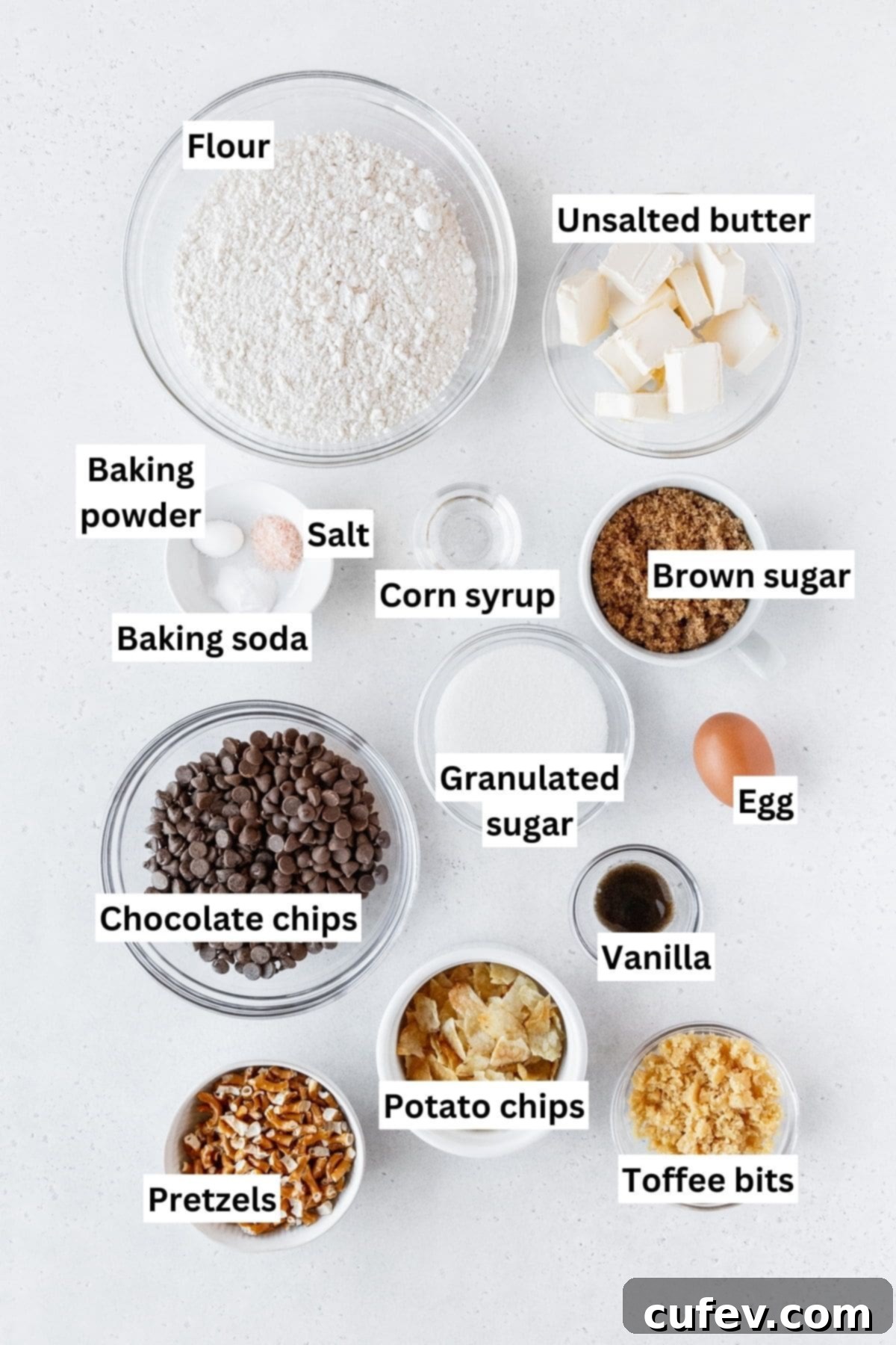 Kitchen sink cookie ingredients measured out into bowls on a white surface with text overlay.