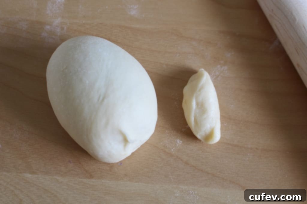 Preparing the last piece of dough to shape into a custom bun, separating a small portion for facial features.