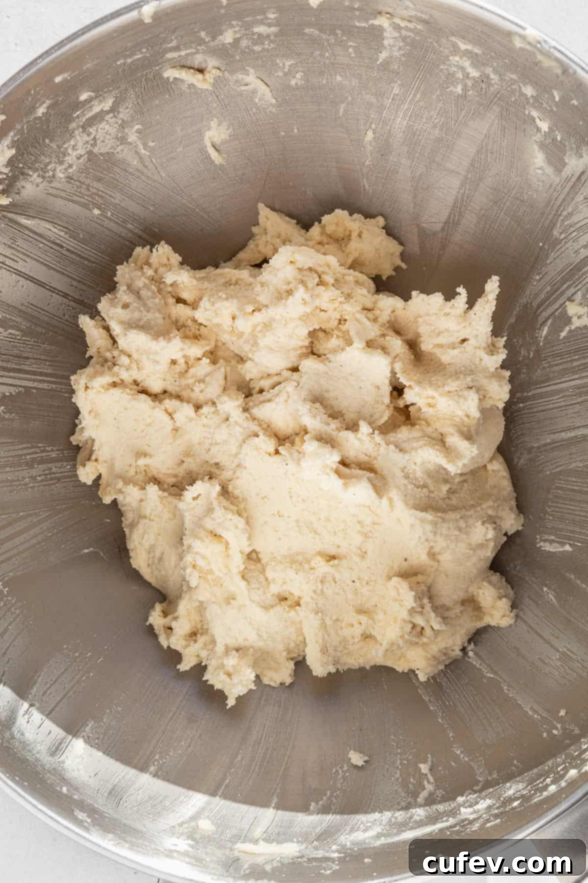 Gluten free sugar cookie dough in a large metallic bowl.