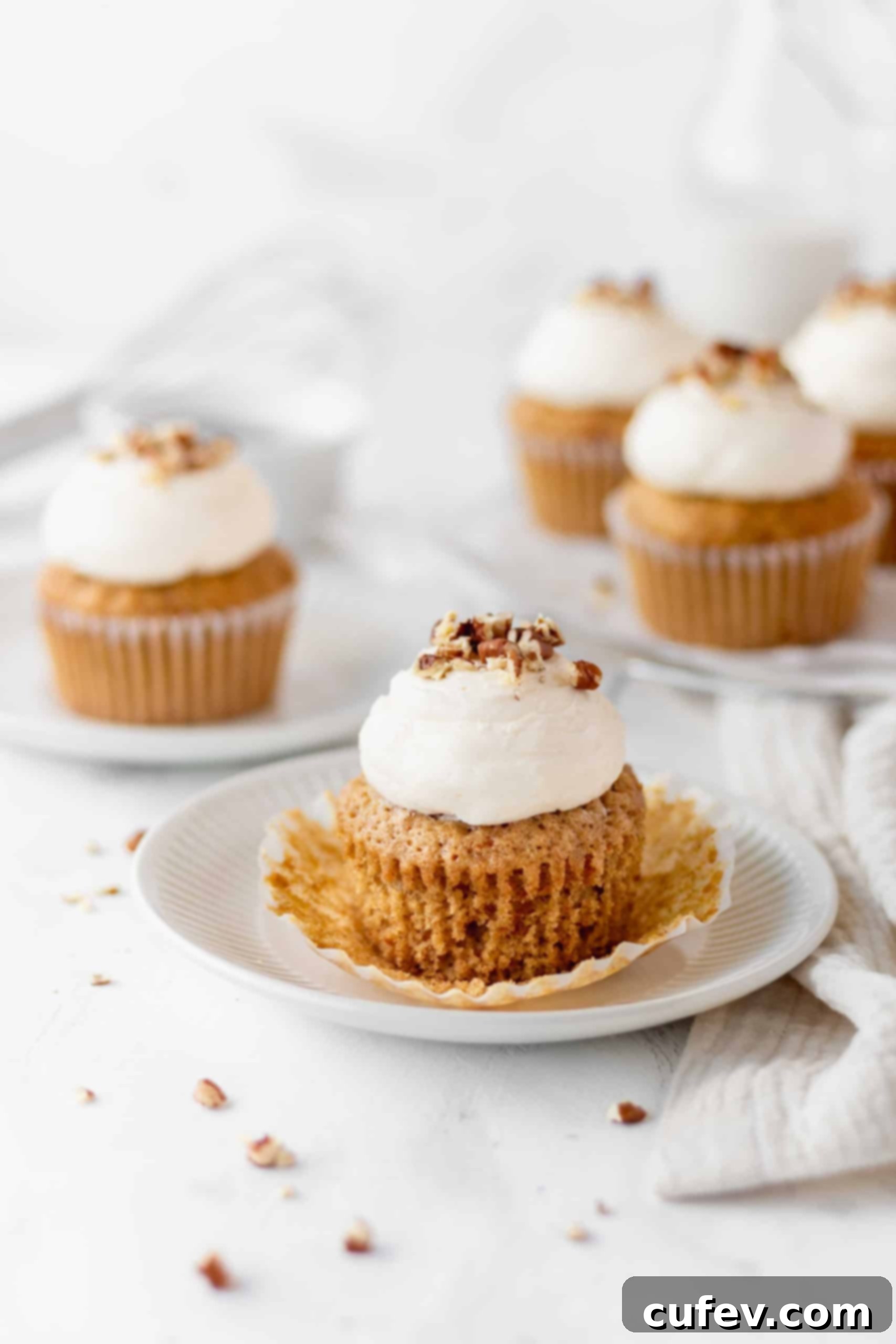Carrot cake cupcake on a plate with the paper liner peeled