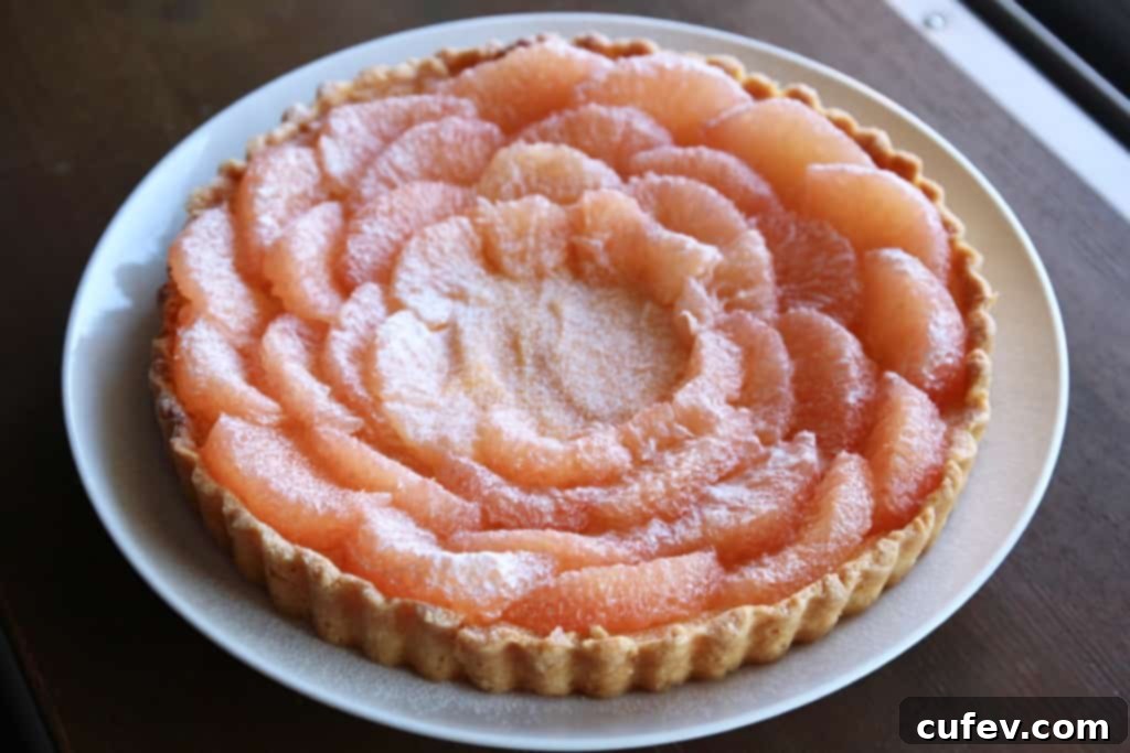 Neatly segmented grapefruit pieces arranged on a clean cutting board, ready for tart garnish.