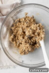 Gluten free oatmeal cookie dough in a glass bowl with a white silicone spatula.